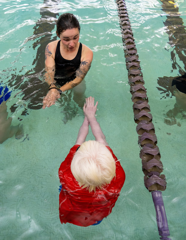 Photo of a coach teaching an athlete the streamline position