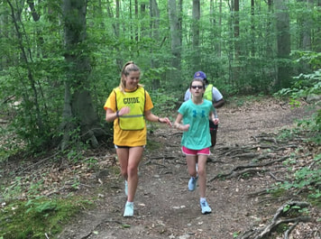Photo of a coach guide running with an athlete in the Gordon Natural Area