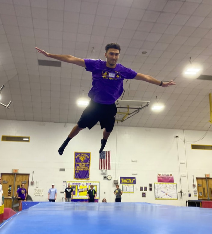 Kyle flies through the air after jumping on a spring board at Wellness Day. 